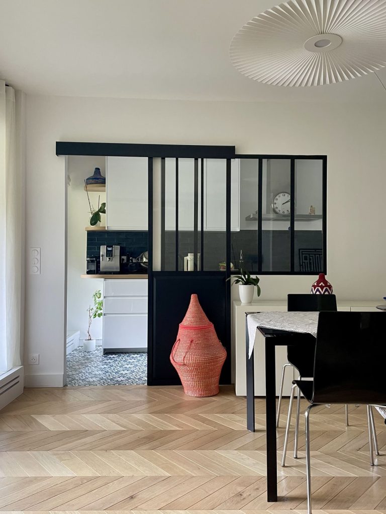 une verrière noire sépare la salle à manger de la cuisine