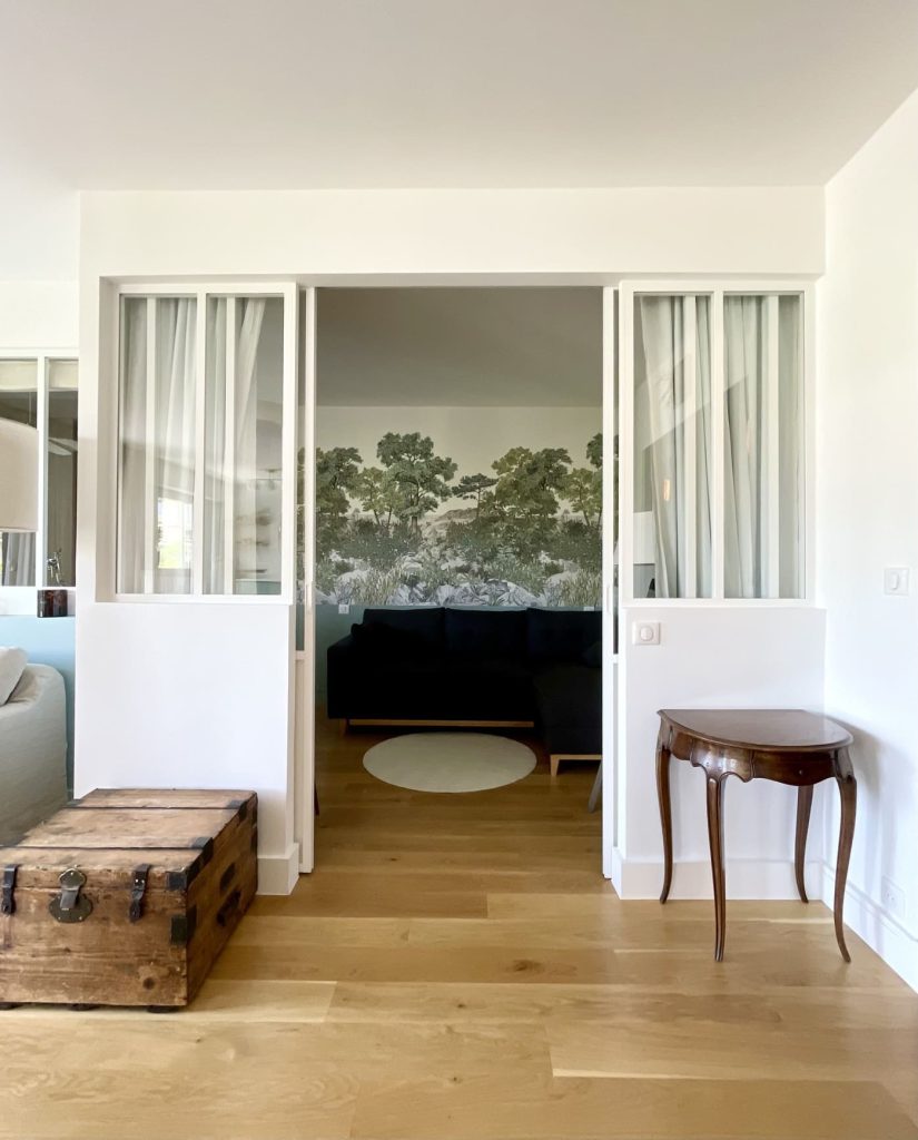 une grande verrière blanche sépare le bureau / chambre d'amis de la pièce de vie