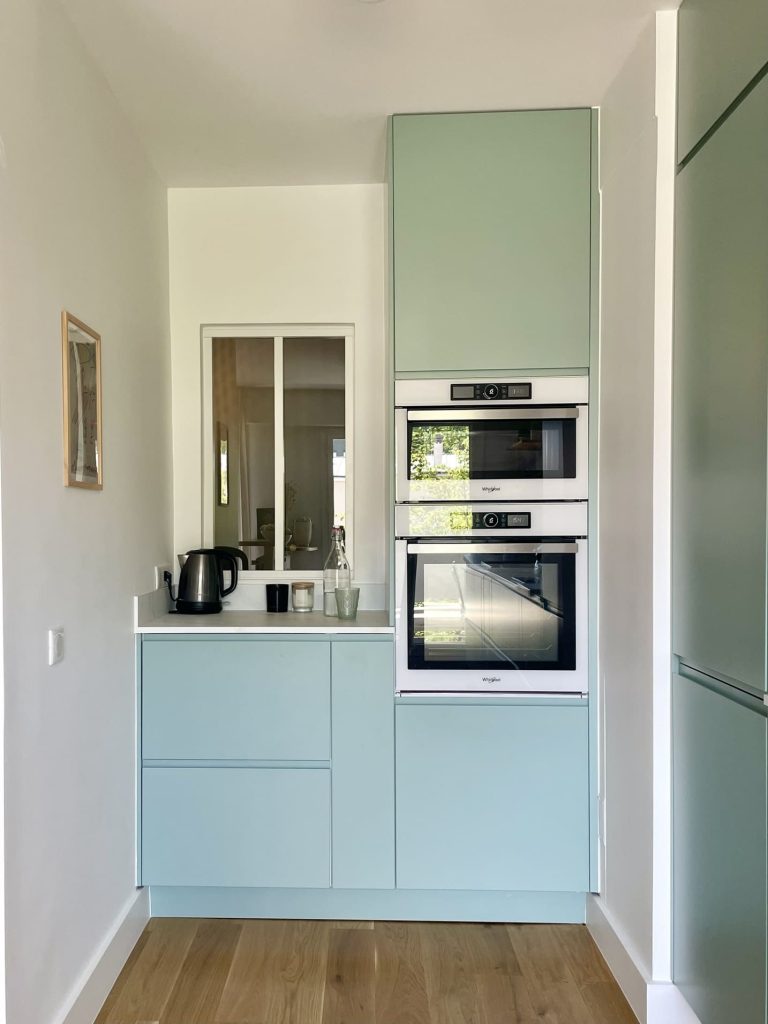 coin technique de la cuisine avec façades bleu et plan de travail en marbre